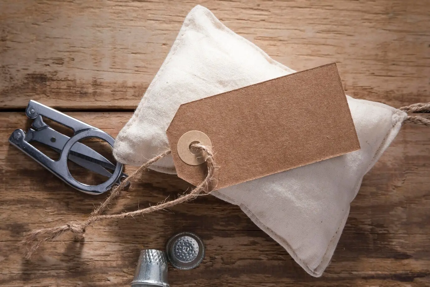 Draufsicht auf eine Schere mit Fingerhüten und Etikett.